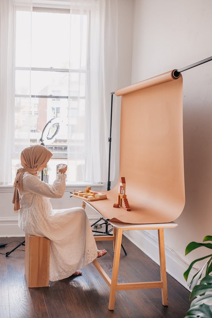 Muslim woman in hijab photographing products in a bright studio setting.
