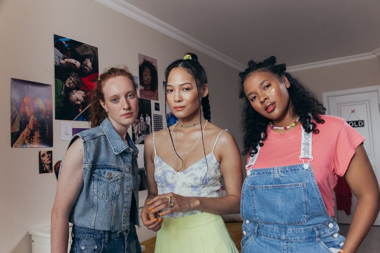 Three diverse women posing confidently in a stylish room with colorful decor.